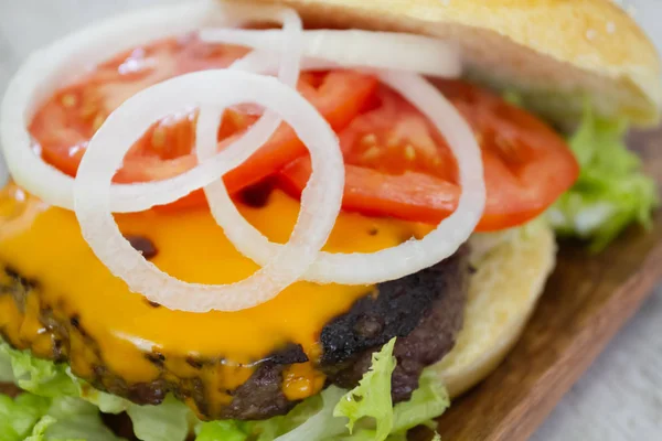 hamburger with a grilled steak on a wooden surface