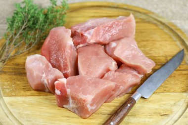 Kesme tahtasındaki çiğ domuz parçaları.