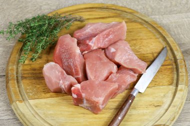 Kesme tahtasındaki çiğ domuz parçaları.