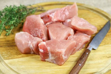 Kesme tahtasındaki çiğ domuz parçaları.