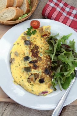Tabağında salata olan mantarlı omlet.