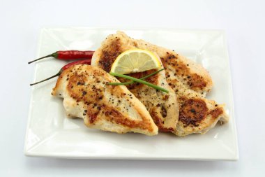 Beyaz arka planda pişirilmiş tavuk filetosu.