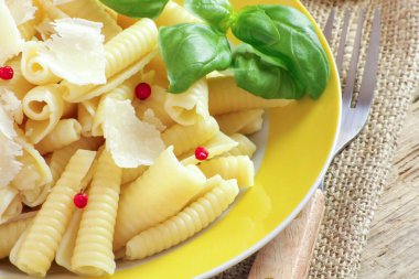 Ahşap bir masada parmesan peynirli makarna.