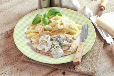 Bir tabak makarna ve mantar soslu tavuk pirzolası.