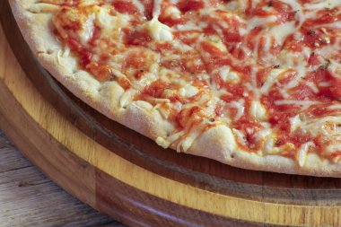 Tahta bir masada margarita pizza.