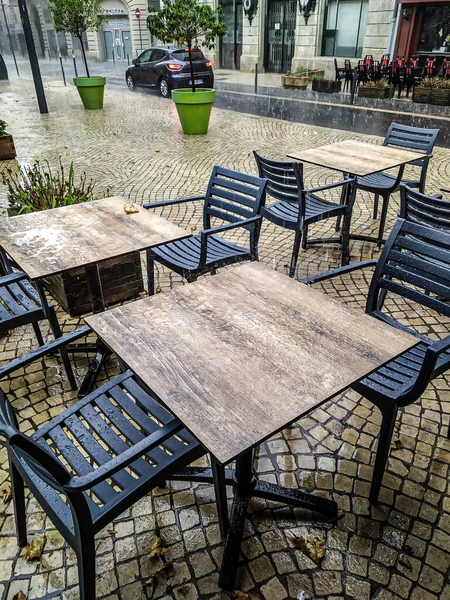 restaurant terrace in a city in the rain