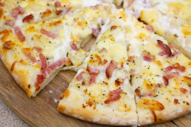 Pizza tahtasında domuz pastırması ve patates pizza.