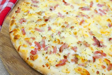 Pizza tahtasında domuz pastırması ve patates pizza.