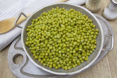 Ahşap bir masada pişmiş bezelye tabağı