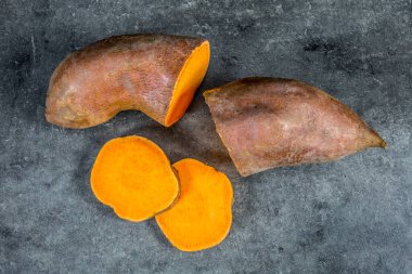 Gri arka planda izole edilmiş tatlı patatesler