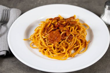 Masada arrabiata olan bir tabak spagetti.