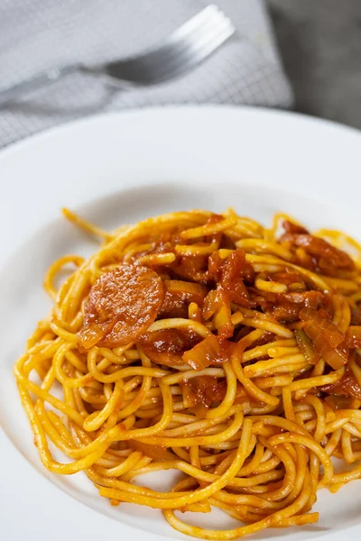 Masada arrabiata olan bir tabak spagetti.