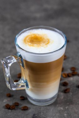 Ahşap bir masada bir bardak kapuçino.