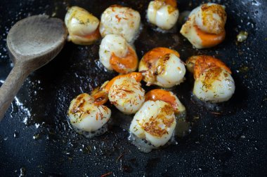 Deniz tarakları tavada pişiyor.