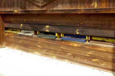 Tahta arı kovanı, arılar uçuşuyor ve girişte sürünüyorlar.