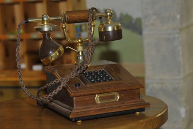 Eski ahşap ahşap telefon. Masanın üzerinde döner bir arama var.