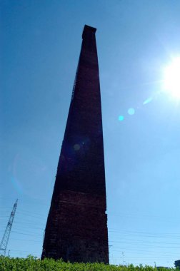 Eskimiş endüstri, arkasında mavi gökyüzü olan fabrika bacası