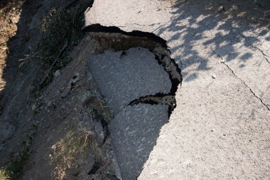 Yol hasarı, yolun bir kısmı kırılmış, kaldırım hasar görmüş.