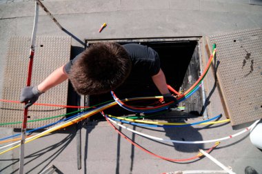 technician with multicolored fiber optic cables for high speed broadband internet clipart