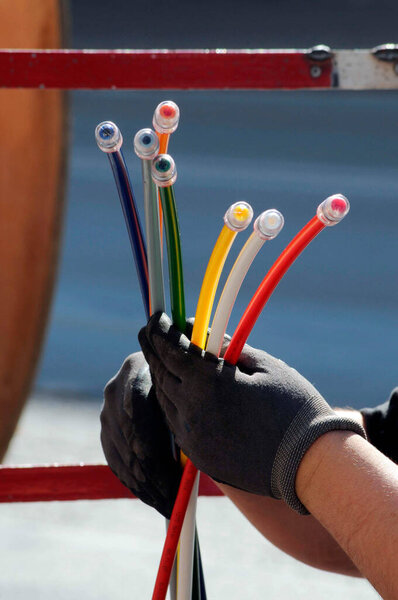 technician with multicolored fiber optic cables for high speed broadband internet