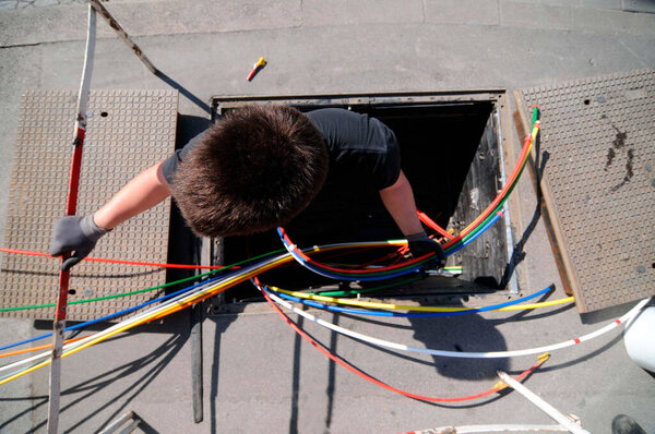 technician with multicolored fiber optic cables for high speed broadband internet