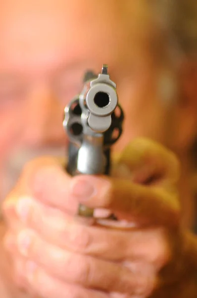 Míří Pistolí Ozbrojený Muž Drží Oběma Rukama Rozmazaný Pozadí — Stock fotografie