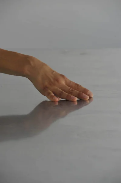 a hand touching reflecting floor, human tactile and haptic perception