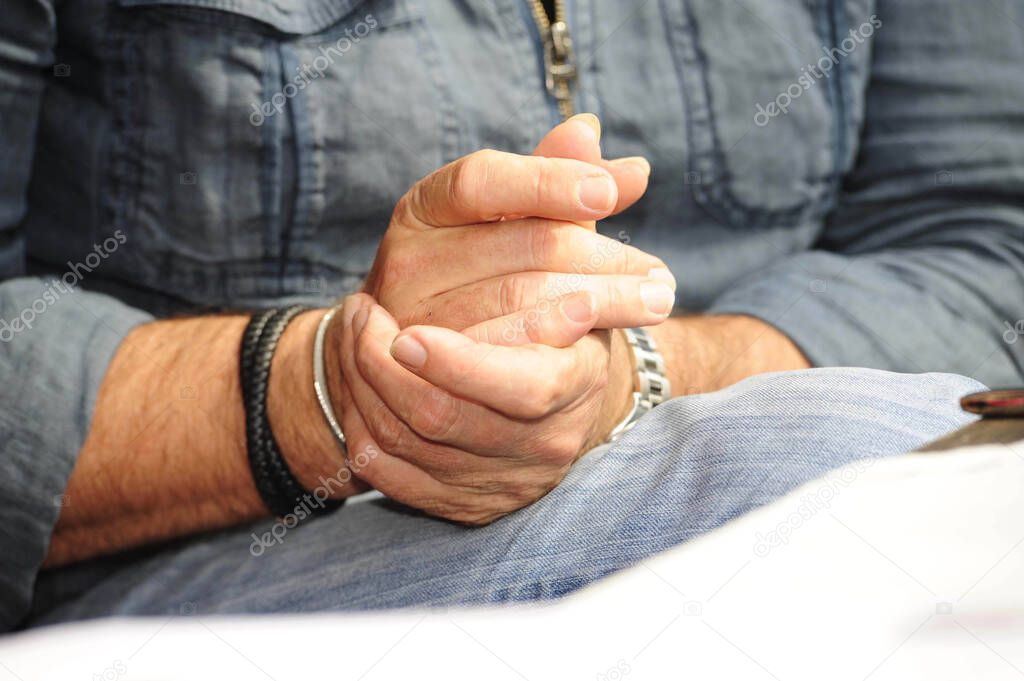 one hand touching the other, person in denim clothing, human tactile and haptic perception