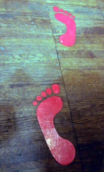 Ausgeschnittene Rote Fußabdrücke Auf Einem Holzboden Barfußsymbol — Stockfoto