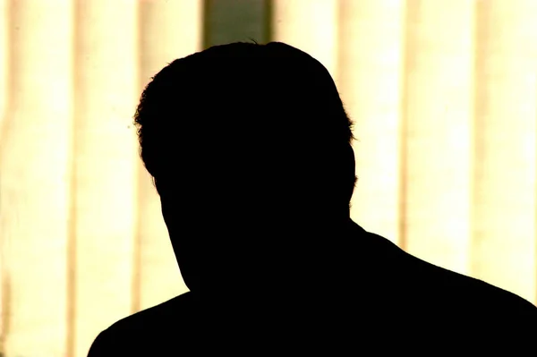 silhouette of a man, bright background light, symbol for corruption and tax fraud