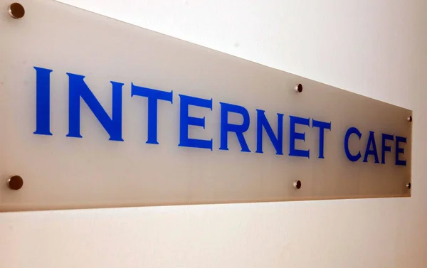 Internet Cafe sign with blue font, online connection and access