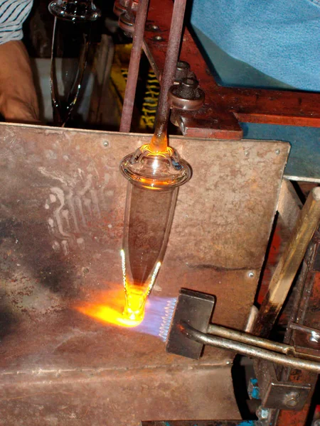 Glassblower at his working place, working with heat and glass