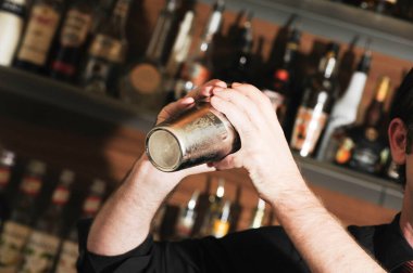 Barmen ya da barmen bir barda içkileri karıştırıyor.