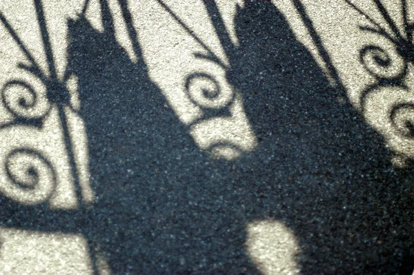 阳光灿烂的日子 人行道上篱笆的影子 — 图库照片