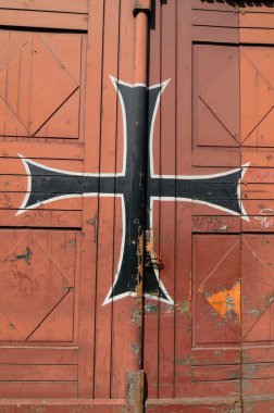 Kapıda Tötonik düzen işareti, beyaz kenarlı siyah haç.
