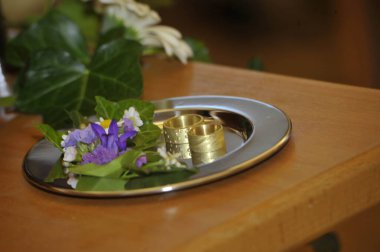 Gümüş bir tepside altın alyanslar Çiçek süslemeleri, sadakat sembolü