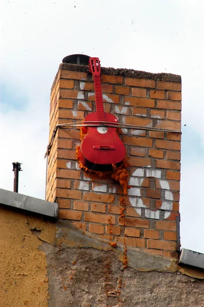 Egy Piros Festett Gitár Lóg Egy Régi Tégla Kémény — Stock Fotó