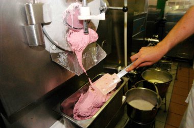 Dondurma makinesi ve pembe renkli çilekli dondurma üretimi.