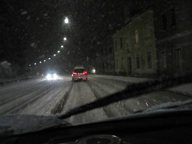 Gece karlı kış manzarasında araba sürerken görüş koşulları