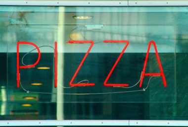 Yeşil pizzacının arkasındaki kırmızı ışık pizza tabelası.
