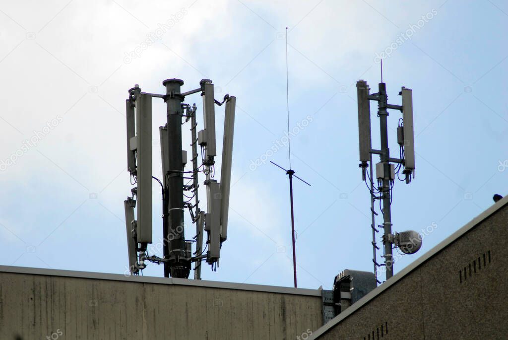 mobile network antennas on top of a building, blue sky