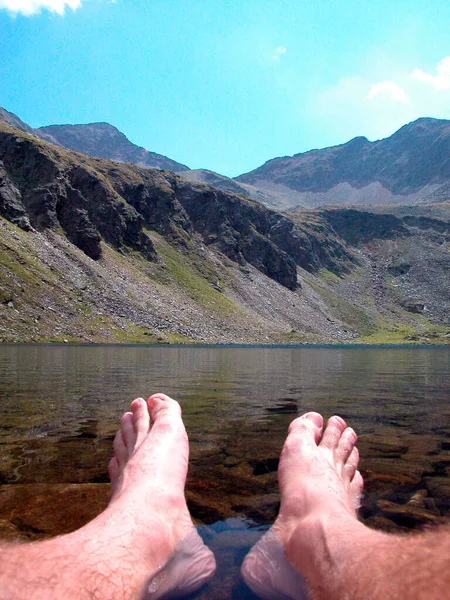 feet in the water at a mountain lake in the alps