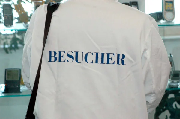 Personne Portant Une Chemise Blanche Mot Besucher Visiteur Imprimé Bleu — Photo