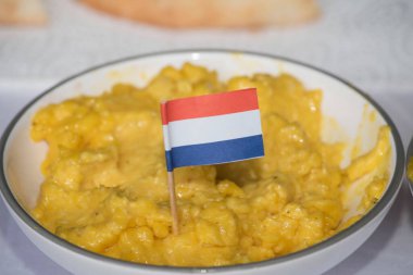 Hollanda 'nın küçük bayrağıyla bir kasede sarı kahvaltı.