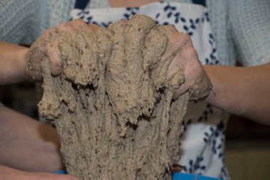 Kadın ev yapımı ekmek hamuru yapıyor, ekmek hamurunu elle yoğuruyor.