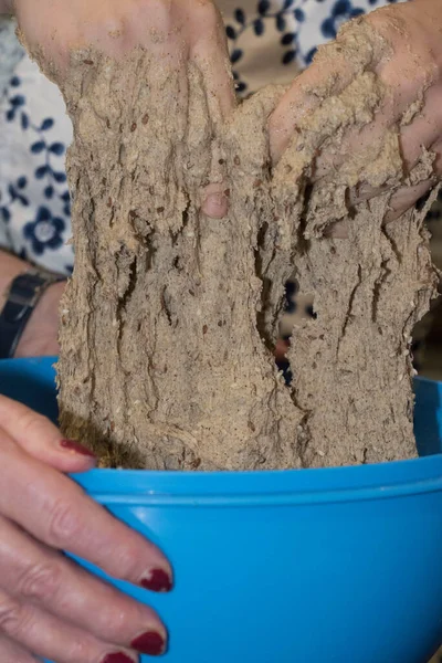 Kadın ev yapımı ekmek hamuru yapıyor, ekmek hamurunu elle yoğuruyor.