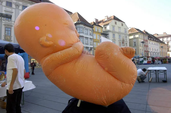 a big inflatable human embryo in public space, fetus symbol