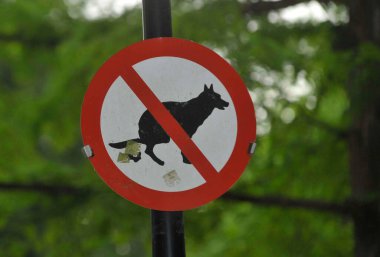 Parkta köpek dışkısı yasaktır, kırmızı daire ve köpek dışkısı.