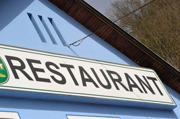 Εστιατόριο Υπογράψει Ένα Κτίριο Μαύρα Γράμματα Λευκή Πινακίδα Μπλε Τοίχο — Φωτογραφία Αρχείου