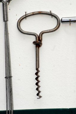 Beyaz arka planda şarap şişesi açmak için metal tirbuşon